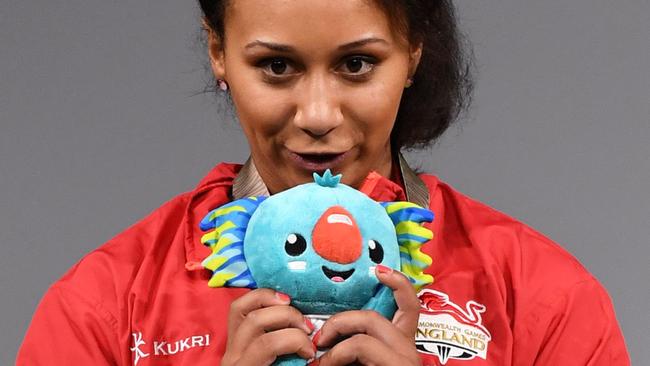 Silver medallist Zoe Smith of England kisses the 2018 Gold Coast Commonwealth Games mascot Borobi after the women's 63kg weightlifting event at the Carrara Sports Arena on the Gold Coast on April 7, 2018.  / AFP PHOTO / WILLIAM WEST