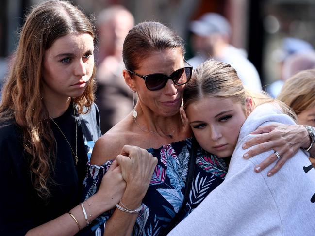 People grieve at the tribute area. Picture: David Gray/AFP