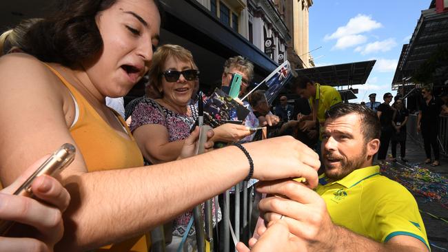 Australian wheelchair racer Kurt Fearnley shares his medals with fans during a street parade in honour of Gold Coast Commonwealth Games athletes through central Brisbane, Friday, April 27, 2018. (AAP Image/Dan Peled) NO ARCHIVING