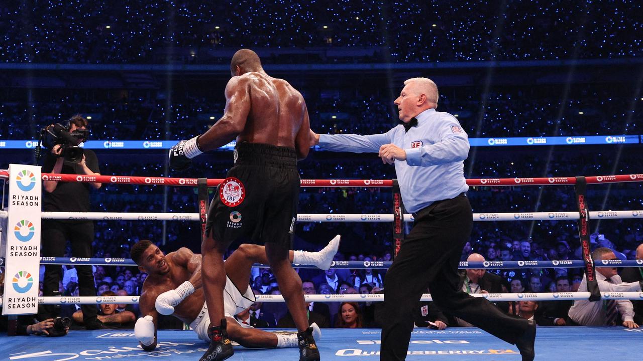 Britain's Anthony Joshua is knocked to the ground by Britain's Daniel Dubois during their heavyweight boxing match for the IBF world title at Wembley Stadium in London on September 21, 2024. (Photo by Adrian Dennis / AFP)