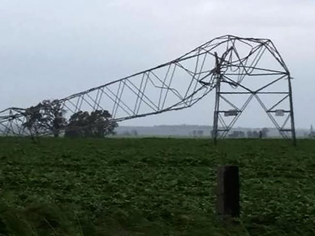 A photo taken on September 28 and obtained on September 29, 2016, shows transmission towers carrying power lines, toppled by high winds near Melrose in South Australia.  Australia on Thursday after "unprecedented" thunderstorms knocked out supply to the entire population. The blackout caused chaos and widespread damage was reported as authorities warned of more wild weather to come. / AFP PHOTO / DEBBIE PROSSER / DEBBIE PROSSER