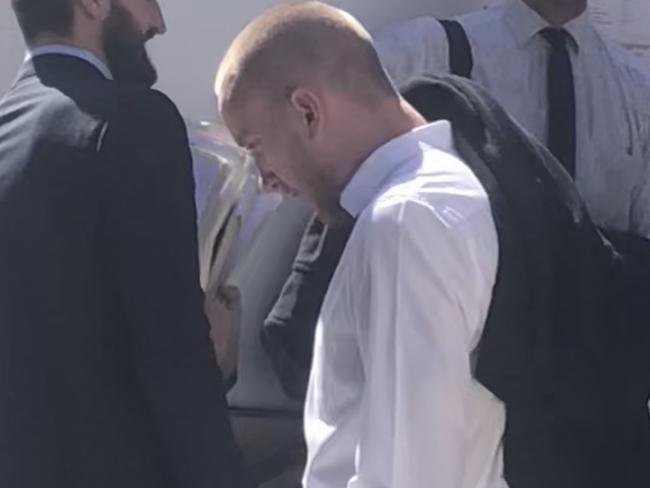 Adam Fawcett (centre), an 26-year-old apprentice electrician from Palm Beach, outside Manly Local Court where he was sentenced to 10 months’ home detention for being caught driving without a licence. It was the fifth time he had been caught in the last three years. Picture: Manly Daily