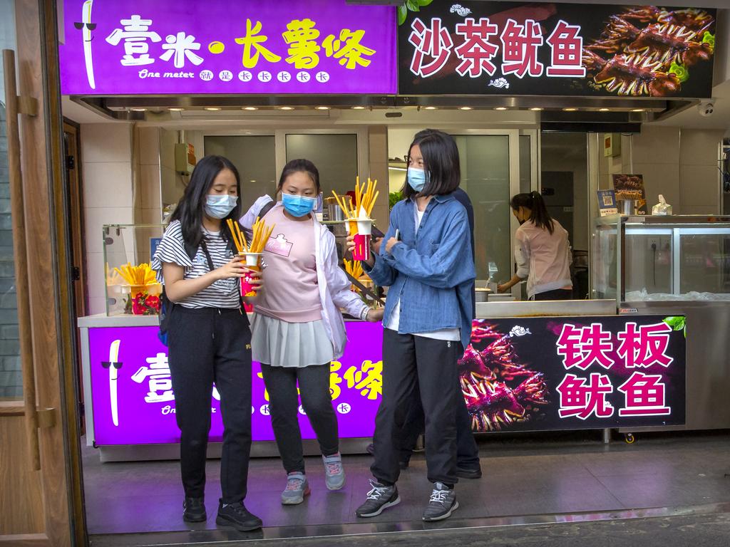 Australia has secured the support of 62 nations for an independent probe into the origins of the coronavirus. In this image, people wearing face masks to buy snacks at a shop on a pedestrian shopping street in Beijing. Picture: Mark Schiefelbein