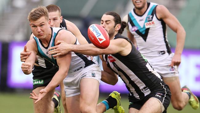 Port Adelaide's Ollie Wines clears with a handpass under heavy attention. Picture: Michael Klein