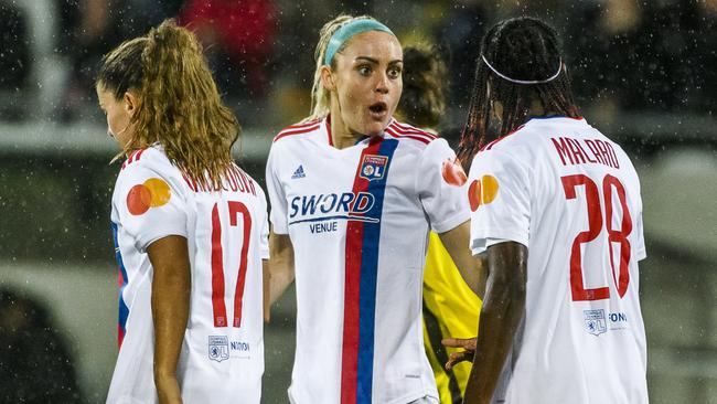 Danielle Van de Donck, Ellie Carpenter and Melvine Malard of Olympique Lyonnais celebrate after their teammate scores.