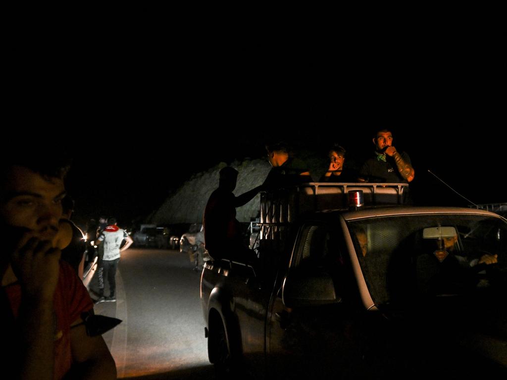 People sit in the back of a truck during a fire near the village of Malona in the Greek island of Rhodes. Picture: AFP