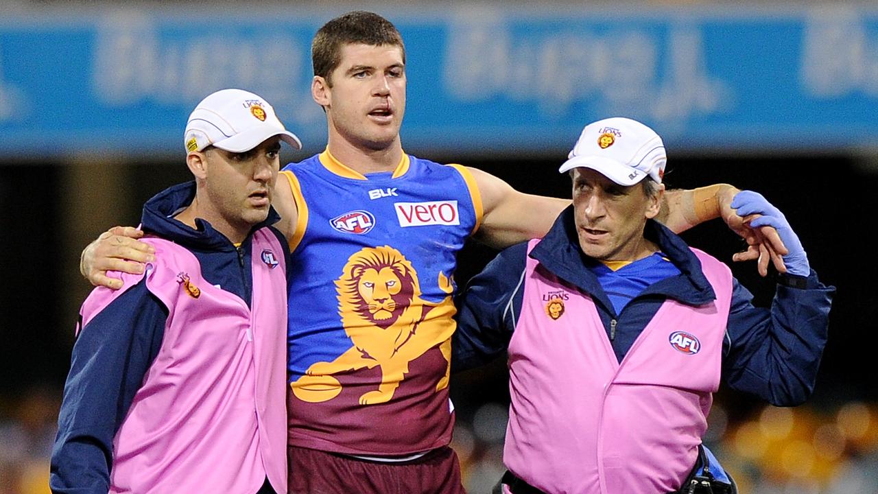 Jonathan Brown of the Lions is assisted from the field in 2014. Picture: Matt Roberts