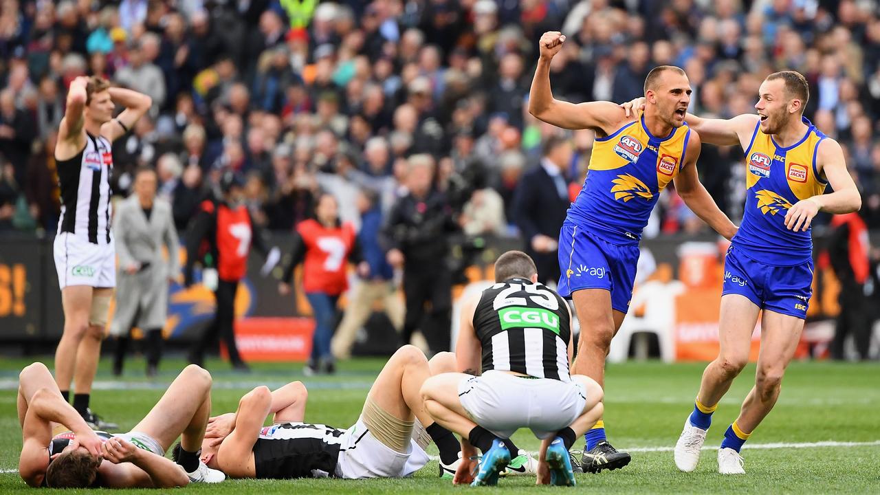 Dom Sheed and Daniel Venables celebrate as Collingwood players fall to the ground as the final siren of the 2018 grand final sounds. Picture: Quinn Rooney/Getty Images