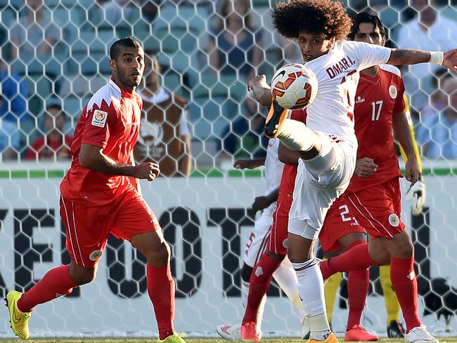 Omar Abdulrahman (C) of United Arab Emirates fights for the ball with Bahrain's Abdulwahab Ali Alsafi (L) during the Asian Cup football match between Bahrain and United Arab Emirates in Canberra on January 15, 2015. AFP PHOTO / Saeed Khan --- IMAGE RESTRICTED TO EDITORIAL USE - STRICTLY NO COMMERICAL USE --