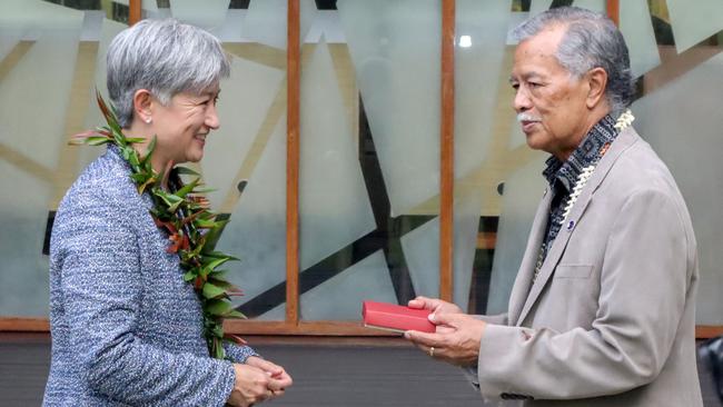 Foreign Minister Penny Wong exchanges gifts with Henry Puna, the secretary-general of the Pacific Island Forum, in Suva, Fiji, on Thursday. Picture: Getty Images