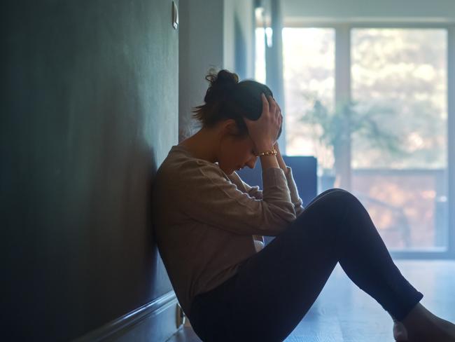 istock generic:  woman, abuse, DV, domestic violence, harassment, sexual harassment.   Sad Young Woman Sitting on the Floor In the Hallway of Her Appartment, Covering Face with Hands. Atmosphere of Depression, Trouble in Relationship, Death in the Family. Dramatic Bad News Moment . Picture: istock