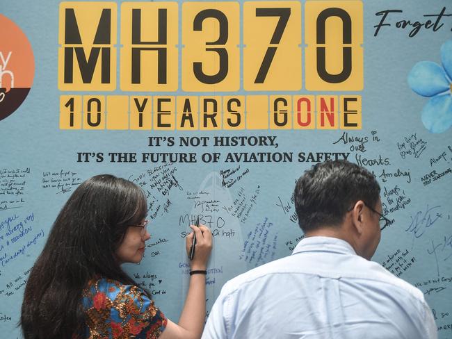 TOPSHOT - A woman writes a message during an event held by relatives of the passengers and supporters to mark the 10th year since the Malaysia Airlines flight MH370 carrying 239 people disappeared from radar screens on March 8, 2014 while en route from Kuala Lumpur to Beijing, in Subang Jaya on March 3, 2024. (Photo by Arif Kartono / AFP)