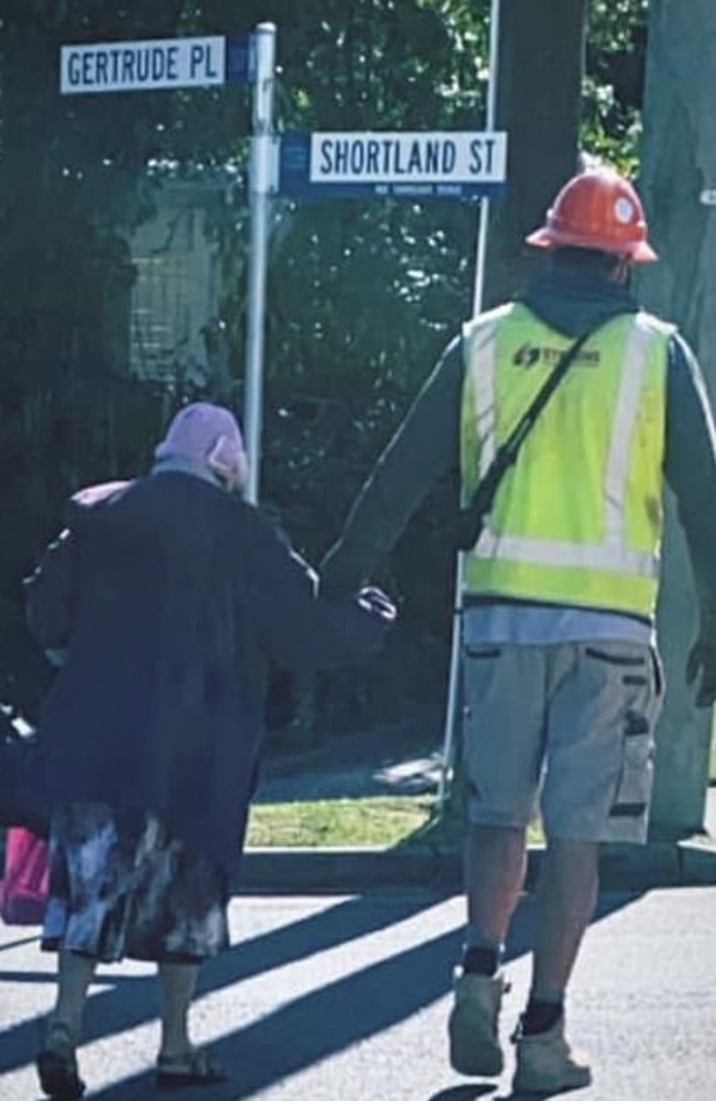 The image of the tradie helping an elderly woman cross the road has gone viral.