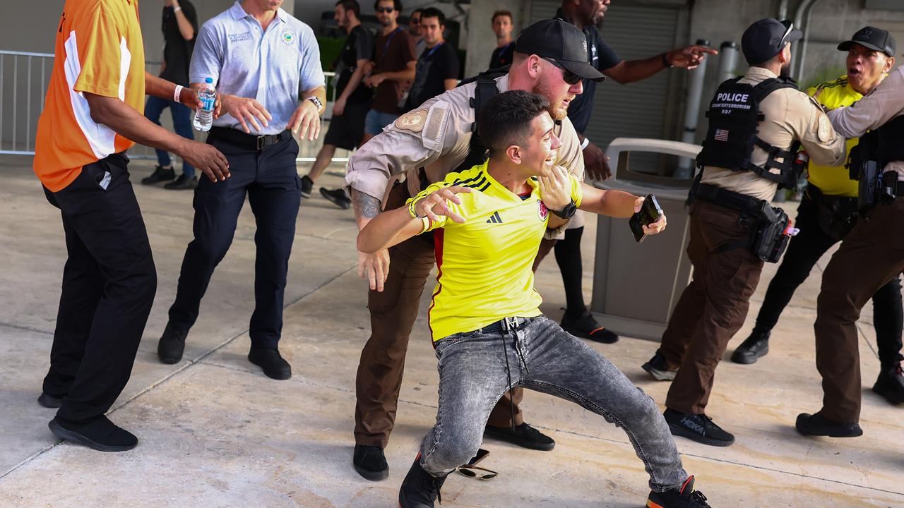 Police officers try to arrest a Colombian fan. Photo by Maddie Meyer/Getty Images.