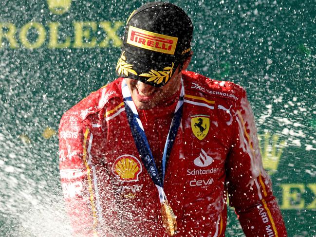 Ferrari's Spanish driver Carlos Sainz Jr sprays champagne to celebrate victory on the podium after the Australian Formula One Grand Prix at Albert Park Circuit in Melbourne on March 24, 2024. (Photo by Martin KEEP / AFP) / -- IMAGE RESTRICTED TO EDITORIAL USE - STRICTLY NO COMMERCIAL USE --