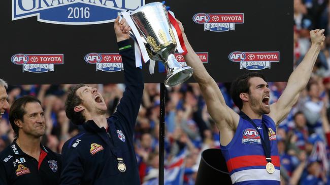 Luke Beveridge smiles as Bob Murphy and Easton Wood hold the 2016 premiership cup aloft. Picture: Wayne Ludbey