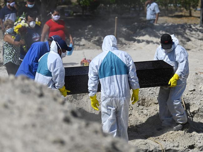 Workers wearing protective suites as a preventive measure against the spread of the new coronavirus bury a coffin at La Bermeja Cemetery in San Salvador. Picture: AFP