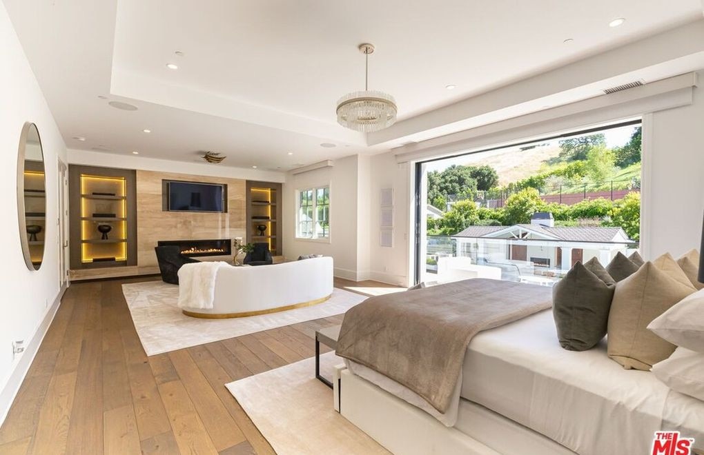One of the bedrooms features a sitting area with a fireplace and a terrace that looks out into the backyard. Picture: Realtor