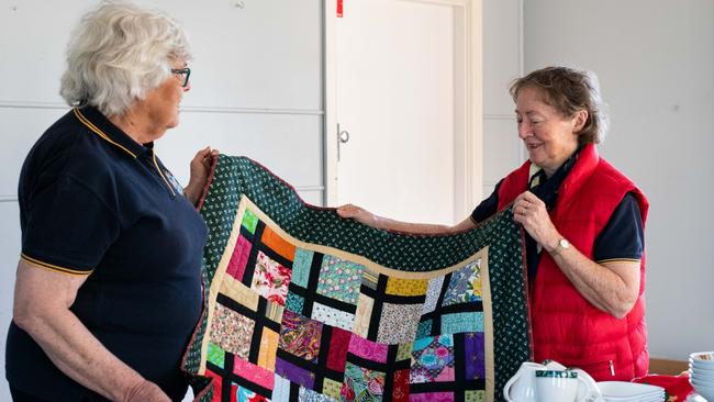 Margaret Swift and Frances Anderson with quilts and homewares donated to the town by generous people across Australia.