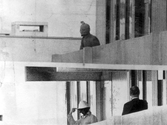 A terrorist wearing a makeshift face mask while he peers out from balcony of Israeli Olympic squad's headquaters at Olympic village in Munich, 1972. Picture: Supplied