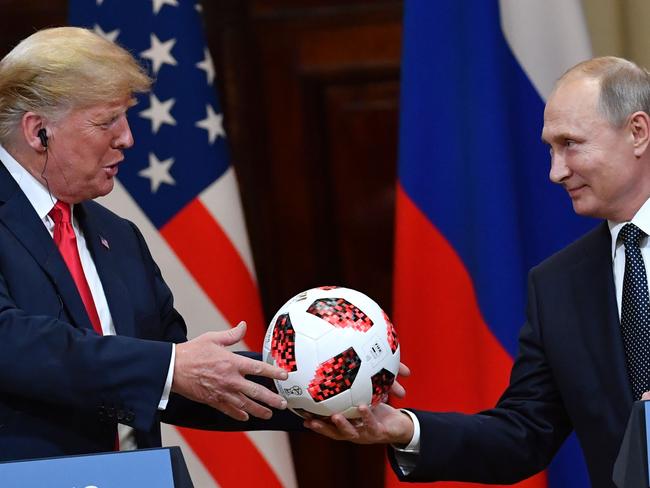 Russia's President Vladimir Putin offers a ball of the 2018 football World Cup to US President Donald Trump during a joint press conference. Picture: AFP