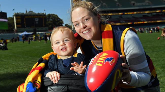 Shannon Dobbin, 29, with Finn, 14, months, gather at Adelaide Oval to welcome back the players after their loss in Saturday’s AFL Grand Final. Picture: Tom Huntley