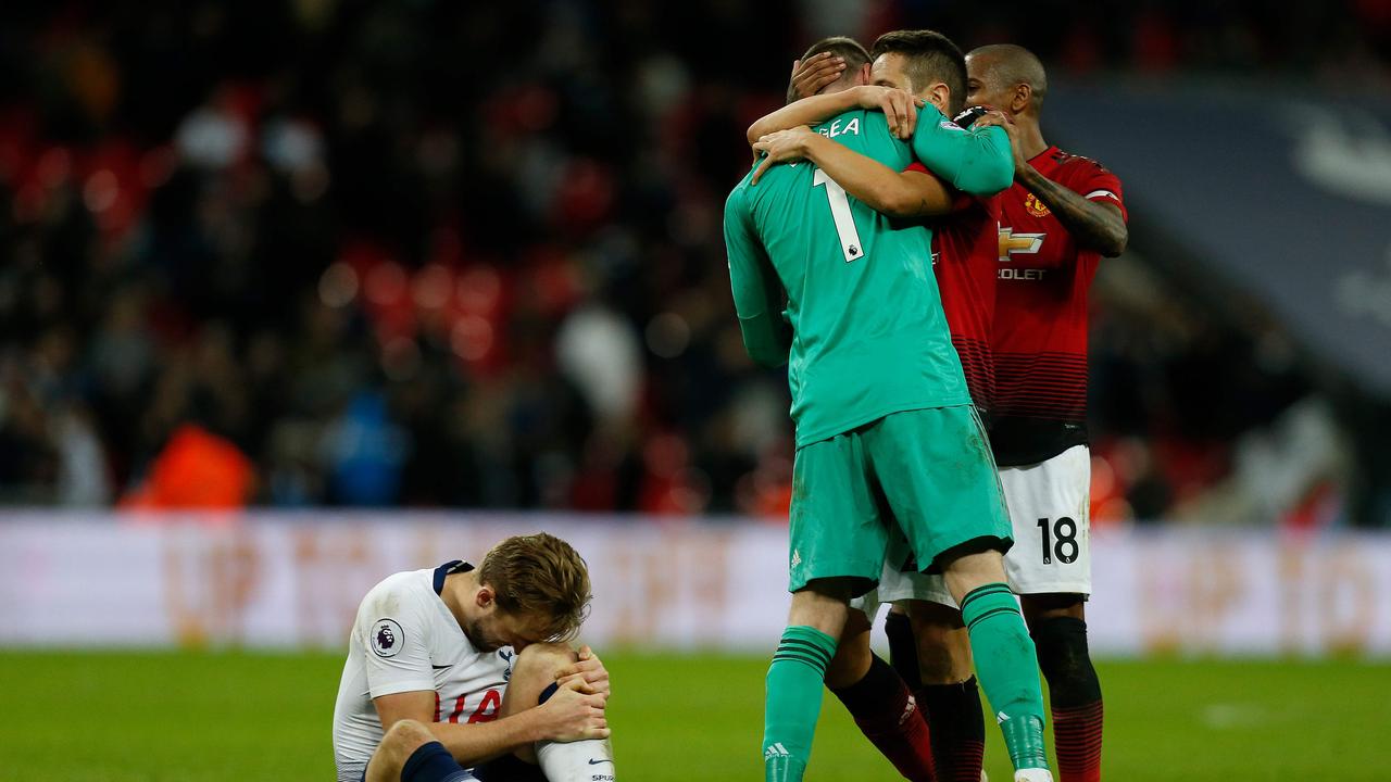 Tottenham Hotspur's English striker Harry Kane (L) holds his leg in pain as players congratulate Manchester United's Spanish goalkeeper David de Gea