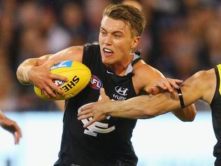 MELBOURNE, AUSTRALIA - MARCH 23:  Patrick Cripps of the Blues runs with the ball as he is tripped by Dan Butler of the Tigers during the round one AFL match between the Carlton Blues and the Richmond Tigers at Melbourne Cricket Ground on March 23, 2017 in Melbourne, Australia.  (Photo by Michael Dodge/Getty Images)