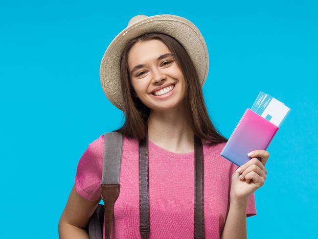 A young female traveller with her camera and boarding passes and about to leave on an overseas holiday. Picture: iStock.