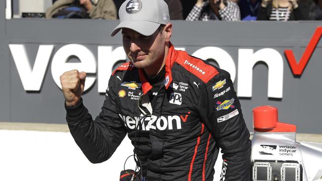 Will Power, of Australia, celebrates as he climbs out of his car after winning the pole for the Grand Prix of Indianapolis IndyCar.