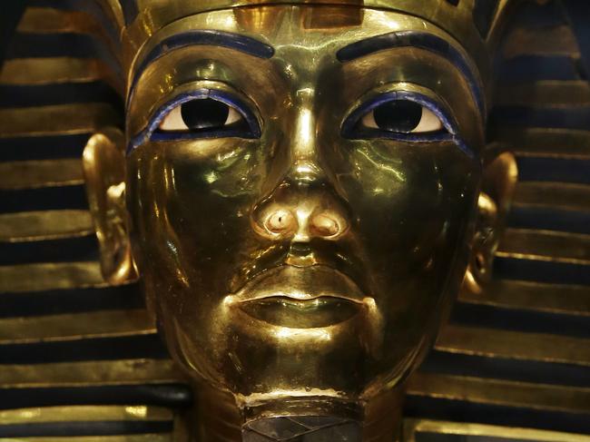 The gold mask of King Tutankhamun is seen in a glass case during a press tour, in the Egyptian Museum near Tahrir Square, Cairo, Egypt, Saturday, Jan. 24, 2015. German restoration specialist, Christian Eckmann, summoned to Cairo to examine the damaged burial mask, spoke at a packed news conference Saturday at the Egyptian museum, saying that epoxy used to glue the mask's beard back on can be removed and the mask properly restored. Eckmann said the beard, which has been detached before from the mask and had likely loosened over the years, was accidentally knocked off last August during work on the relic’s lighting. (AP Photo/Hassan Ammar)