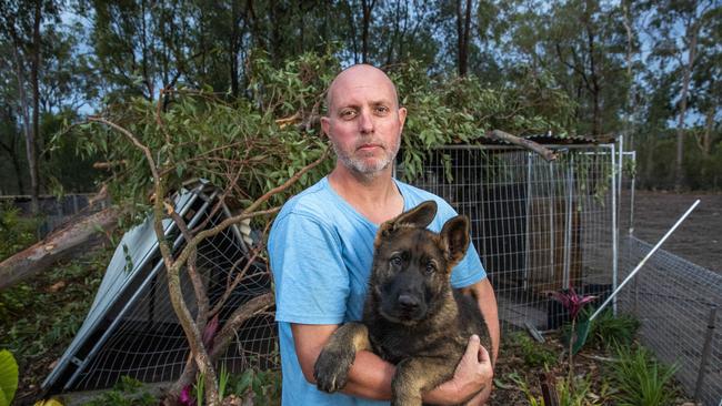 Matt Steiler with Gas the puppy, saved from a kennel crushed by a fallen tree in Karalee. Picture: Richard Walker