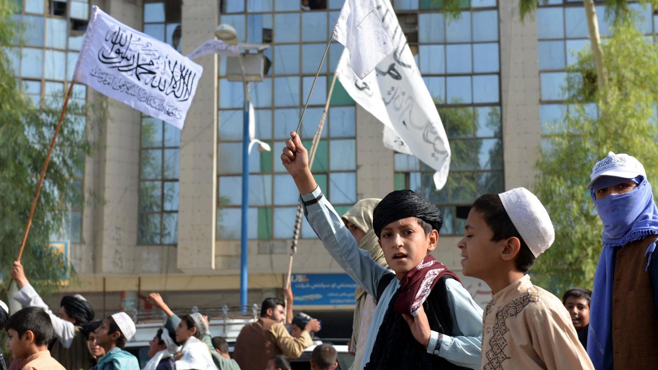 ouths supporting the Taliban wave Taliban flags and shout slogans while marching along a street in Kandahar on August 31.