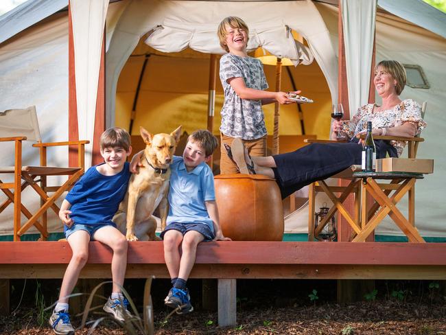 Regional holiday madness at Daylesford Holiday Park. It was so busy last Thursday with online bookings that their website almost went down. Owner Jodie Jagoe at the park's glamping accomodation with Joey (motorcycle t shirt), 9, Tom (dark blue t shirt), 8, and Jesse (light blue t shirt), 6, and Gypsy the yellow kelpie. Picture: Mark Stewart