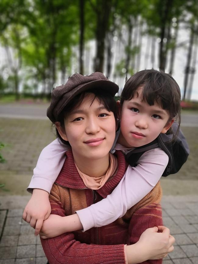 Imogen Carter, 7, hugs her mother in a Wuhan square. Picture: Simon Carter