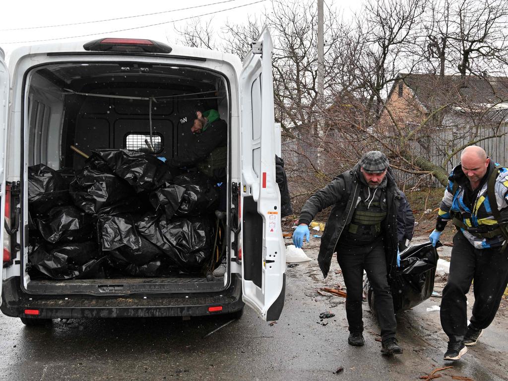 Communal workers carry a body of a civilian man killed by Russian troops shelling in the town of Bucha. Picture: AFP