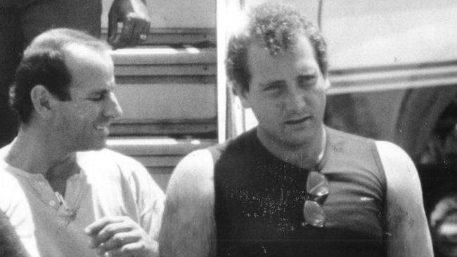 Jonathon Bakewell, right, is escorted by a police officer, left, off a plane at the Darwin Airport after his arrest in 1988.