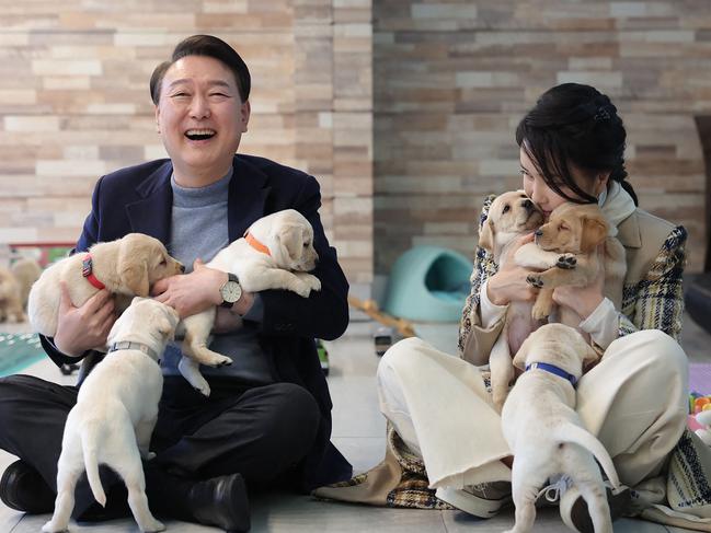 (FILES) This handout photo taken on December 24, 2022 and released by the South Korean Presidential Office shows South Korean President Yoon Suk Yeol and first lady Kim Keon Hee posing with puppies at the Samsung Guide Dog School in Yongin. South Korean lawmakers on December 14, 2024 impeached President Yoon Suk Yeol over his failed martial law bid, with the opposition declaring a "victory of the people". (Photo by Handout / South Korean Presidential Office / AFP) / RESTRICTED TO EDITORIAL USE - MANDATORY CREDIT "AFP PHOTO / SOUTH KOREAN PRESIDENTIAL OFFICE" - NO MARKETING NO ADVERTISING CAMPAIGNS - DISTRIBUTED AS A SERVICE TO CLIENTS