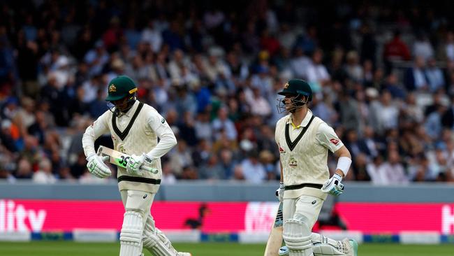 Australia's Usman Khawaja (L) and Steve Smith (R) run from the field as rain stops play. Picture: AFP