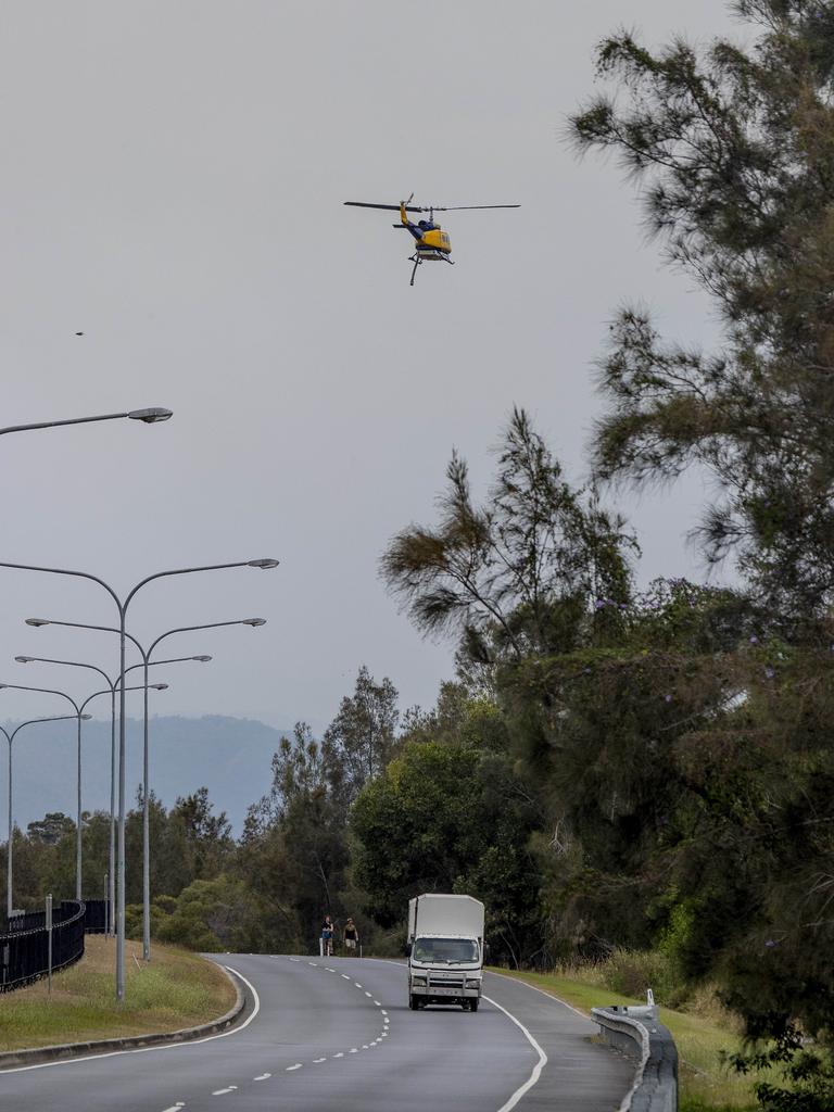 Smoke haze covers the Gold Coast Skyline from a grass fire at Carrara. A firefighting helicopter flying over Gooding Dr in Carrara . Picture: Jerad Williams