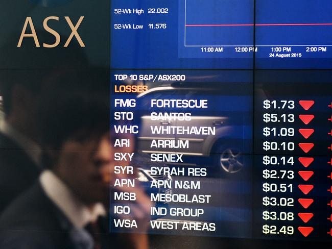 A man is seen in a reflection to stop to look at the electronic share board at the Australian Stock Exchange (ASX) in Sydney, Monday, Aug. 24, 2015. The ASX 200 has dipped below 5100 points for the first time in 18 months, as the big banks continue to bear the brunt of fear selling and with the big miners also getting hit on continued weakness in commodity prices. (AAP Image/Dan Himbrechts) NO ARCHIVING