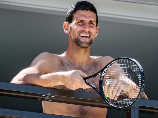 Men's world number one tennis player Novak Djokovic of Serbia waves to fans from a hotel balcony in Adelaide. (Photo by Morgan SETTE / AFP).