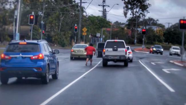 A man charges at a road user forcing the driver to flee through a red light. Picture: Brett Lynch/YouTube