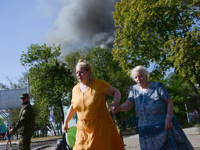 Women rush across the street after shelling in Donetsk yesterday. Picture: Mstislav Chernov