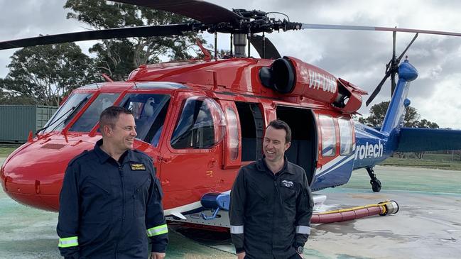 Aerotech pilots Scott Summers and Chris Boyd with the first Black Hawk helicopter to be registered as a civilian aircraft in Australia. Picture: Supplied.