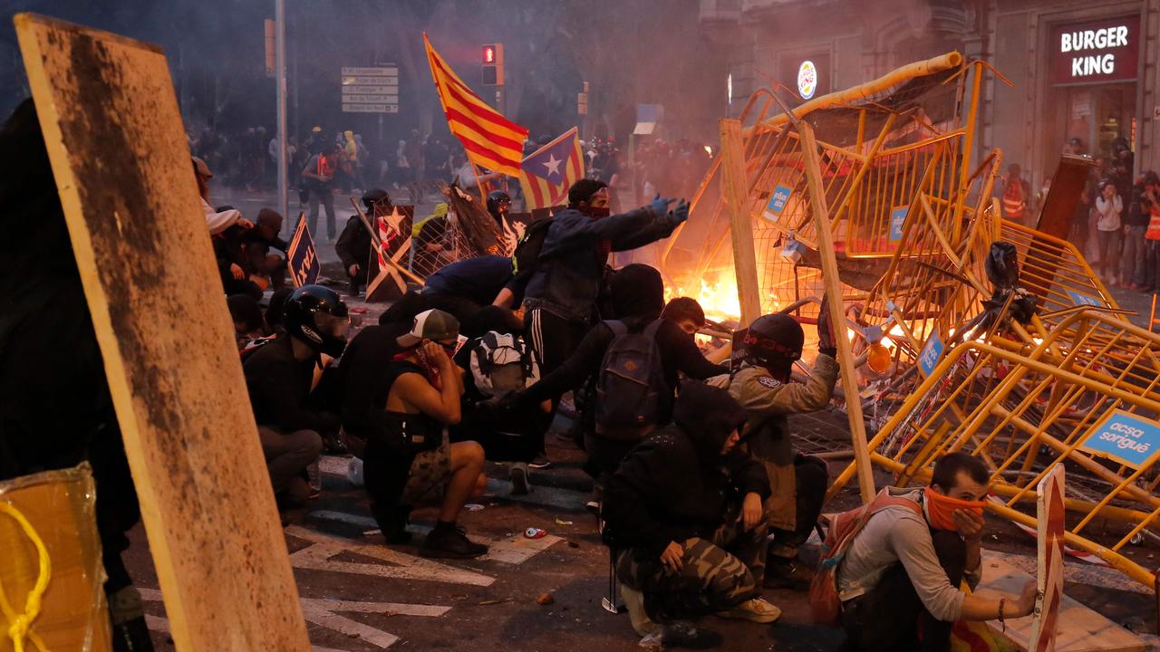 Protesters use fences as a barricade during clashes near Barcelona’s Police headquarters in Barcelona, Photo: Pau Barrena / AFP