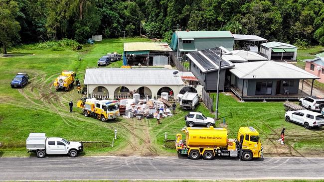 Local residents and Rural Fire Brigade members join Cassowary Coast Council workers clean up a flooded properties on Gregory Street. Picture: Brendan Radke