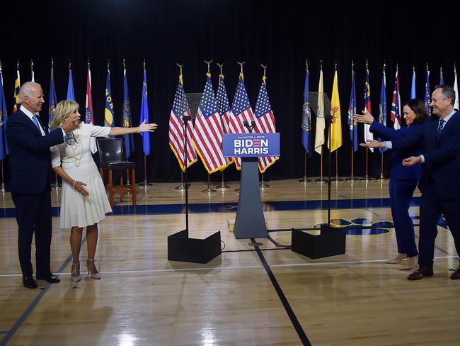 Democratic presidential nominee and former US Vice President Joe Biden and his wife Jill Biden (L) gesture to his vice presidential running mate, US Senator Kamala Harris, and her husband Douglas Emhoff (R) after their first press conference together in Wilmington, Delaware, on August 12, 2020. (Photo by Olivier DOULIERY / AFP)