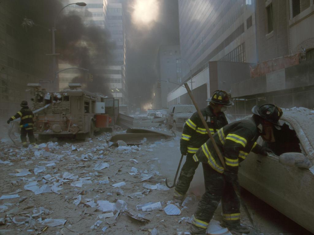 NYC firemen check a car on Barclay St after the 9/11 terrorist attack on the World Trade Centre. Picture: Alamy