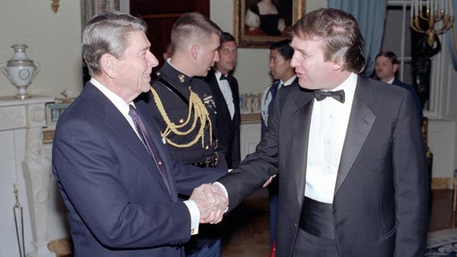 Former US President Ronald Reagan shakes hands with Former US President Donald Trump in a reception line in the White House's Blue Room, Washington DC. November 3, 1987. Picture: White House Photo Office/PhotoQuest/Getty Images